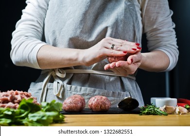 A Female Chef Prepares Swedish Meatballs From Raw Minced Meat. Black Background, Side View, Kitchen