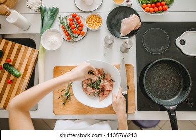 Female Chef Putting Green In The Meet In The Kitchen Room. Add Herbs To The Meat