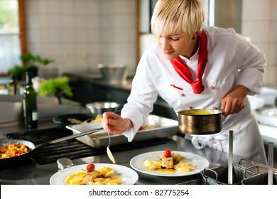 Female Chef In A Restaurant Or Hotel Kitchen Cooking Delicious Food, She Is Decorating The Dishes