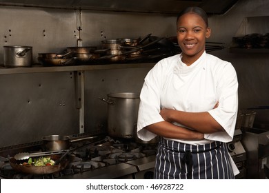 Female Chef Standing Next To Cooker In Restaurant Kitchen