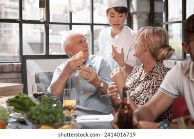 Female chef and students talking in cooking class - Powered by Shutterstock