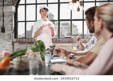 Female chef talking to students in cooking class - Powered by Shutterstock