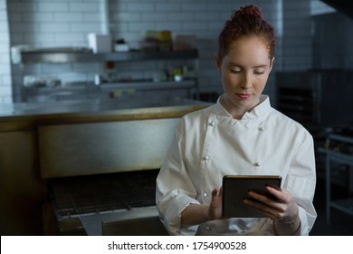 Female chef using digital tablet in the kitchen - Powered by Shutterstock - Get 15% off with code: PIKWIZARD15