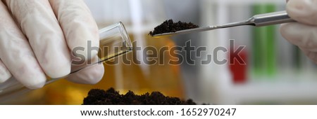 Female chemist in white protective gloves hold test tube against chemistry lab background closeup. Express research crop soil content of beneficial and harmful substances concept