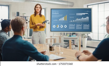 Female Chief Analyst Holds Meeting Presentation for Team Economists  She Shows Digital Interactive Whiteboard and Growth Analysis  Charts  Statistics   Data  People Work in Creative Office 