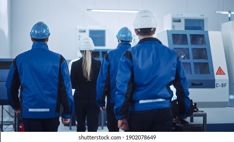 Female Chief Project Manager, Team of Engineers, Workers, Safety, Control Inspector Wearing Hardhats Walk Through Industrial Factory. Facility with CNC Machinery, Robot Arm. Back View Shot - Shutterstock ID 1902078649