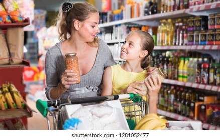 Female and child choosing fresh goods in food department in supermarket