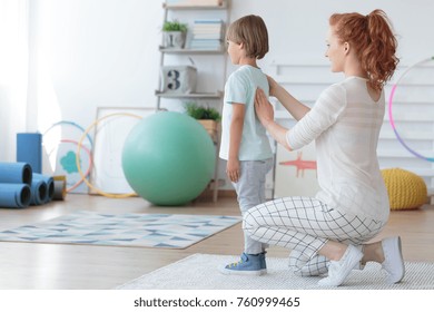 Female child physiotherapist examining little patient's spine in pediatric orthopedic clinic - Powered by Shutterstock