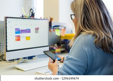 Female child therapist in an office during a phone call, using online calendar to schedule patients appointments. Calendar Planner Organization Management Concept.