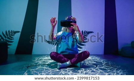 Female child using new technologies, having fun wearing virtual reality goggles in the VR room of natural history museum.