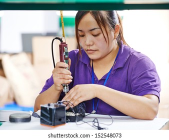 female chinese worker woman assembling production at line conveyor in china factory manufacturing
