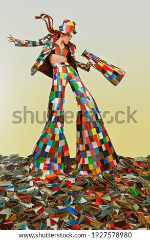 Female circus master dressed in a colorful suit and holding a megaphone, standing in the middle of a bunch of color samples