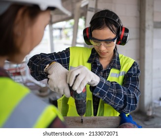 Female Civil Engineer From Asia Is Using An Electric Screwdriver And Wearing Personal Protective Equipment.
Worker Wear A Helmet, Hard Hat, Gloves, Safety Glasses,Ear Muff.Work Safe Concept.Prevention