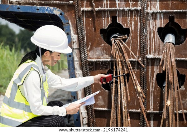 A female civil engineering inspects prestressed\
concrete beams. In construction sites highways road\
constructioncentral ring.