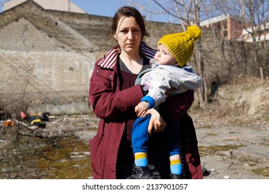 Female Civilian Holding Her Child Among The Ruins