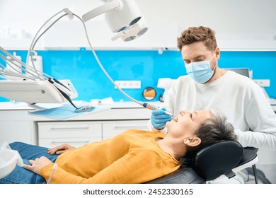 Female client satisfied with thoroughness of her hygienic teeth cleaning - Powered by Shutterstock