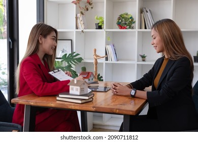 A Female Client Signs A Rental Application Form For A New House. Real Estate Agent Meets With Her Potential Client.