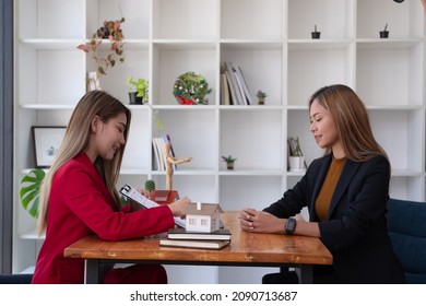 A Female Client Signs A Rental Application Form For A New House. Real Estate Agent Meets With Her Potential Client.