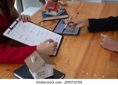 A Female Client Signs A Rental Application Form For A New House. Real Estate Agent Meets With Her Potential Client.