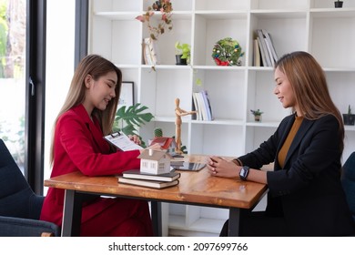 A Female Client Signs A Rental Application Form For A New House. Real Estate Agent Meets With Her Potential Client.