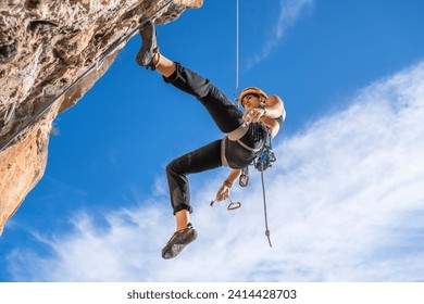 Female climber abseiling from rock face - Powered by Shutterstock