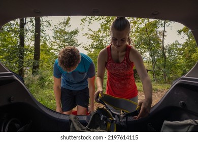 Female Climber And Her Male Climbing Friend Taking Gear Out Of The Car