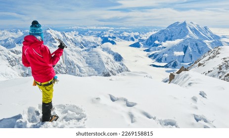 A female climber with ice axe enjoying panoramic view on Mt Denali in Alaska, the highest mountain in North America - Shutterstock ID 2269158815