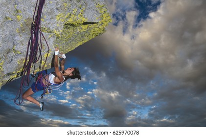 Female climber struggeling up a sheer cliff. - Shutterstock ID 625970078