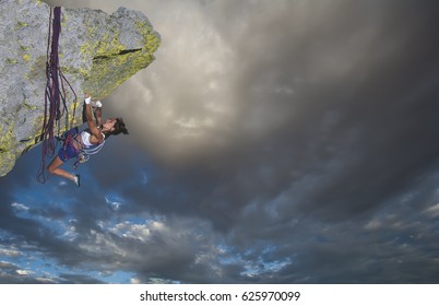 Female climber struggeling up a sheer cliff. - Shutterstock ID 625970099