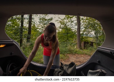 Female Climber Taking Her Climbing Gear Out Of The Car Booth 