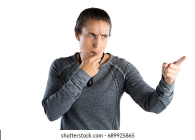 Female coach gesturing while whistling against white background - Powered by Shutterstock
