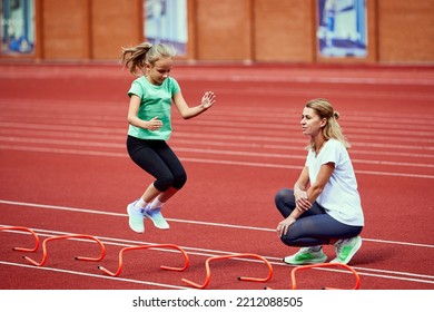 Female Coach Training Athlete. Fit Girl Getting Ready To Run On Treadmill At The Stadium. Concept Of Sport, Achievements, Studying, Goals, Skills. Little Teen Girl In Sportswear Training Outdoor.