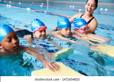 Female Coach In Water Giving Group Of Children Swimming Lesson In Indoor Pool - Shutterstock ID 1472654810