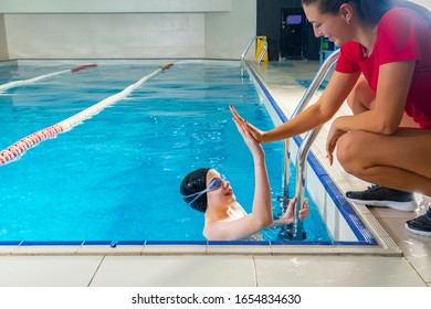 Female Coach In Water Giving preteen boy swimming Lesson In Indoor Pool - Powered by Shutterstock