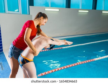 Female Coach In Water Giving preteen boy swimming Lesson In Indoor Pool - Powered by Shutterstock