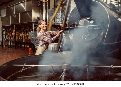 A Female Coffee Factory Worker Operates Coffee Roasting Machine In Facility.