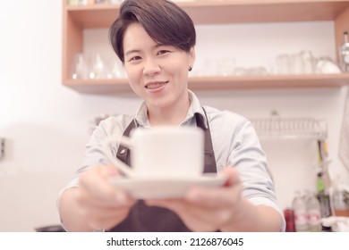 A Female Coffee Shop Business Owner Is Busy Making Coffee In His Shop She Is Serving Coffee That Tastes Great. Which The Atmosphere Is Filled With Happiness .