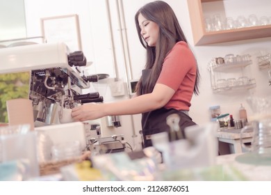 A Female Coffee Shop Business Owner Is Busy Making Coffee With The Coffee Machine In His Shop. Which The Atmosphere Is Filled With Happiness Today Is The First Day That The Shop Is Open.