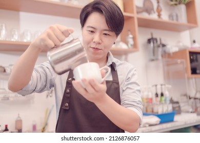 A Female Coffee Shop Business Owner Is Busy Making Coffee In His Shop She Is Serving Coffee That Tastes Great. Which The Atmosphere Is Filled With Happiness .