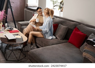 Female colleagues reviewing sketches in a sewing studio - Powered by Shutterstock