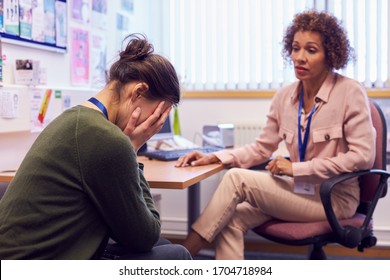 Female College Student Meeting With Campus Counselor Discussing Mental Health Issues