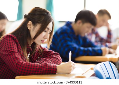 Female College Student Sitting And Exam In The Classroom