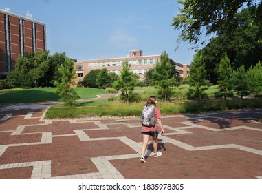 A Female College Student Wearing A Face Mask Walking On College Campus During The Coronavirus Outbreak