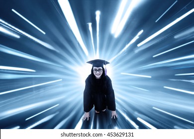 Female College Student Wearing Mortarboard And Ready To Run With Fast Motion Blur Background