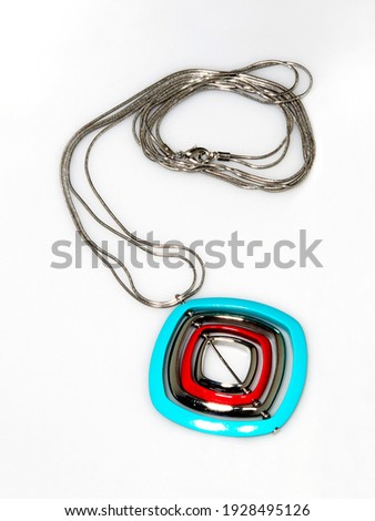Female colorful pendant with silver string on white background. Close-up shot