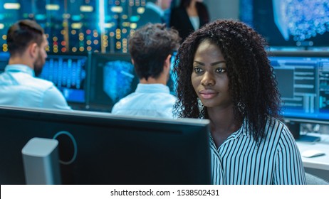 Female Computer Engineer Works on a Neural Network/ Artificial Intelligence Project with Her Multi-Ethnic Team of Specialist. Office Has Multiple Screens Showing 3D Visualization. - Shutterstock ID 1538502431