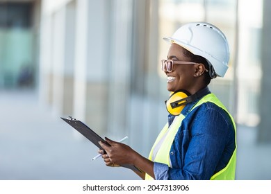 Female construction engineer. Architect with a clip board at a construction site. Young Woman look in camera, building site place background. Female builder, engineer, architect, inspector