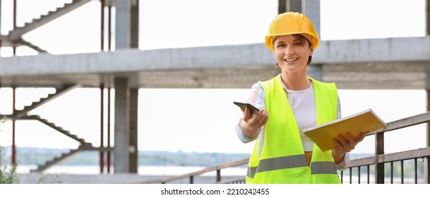 Female Construction Worker With Folder And Mobile Phone At Site