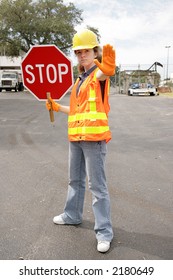 A Female Construction Worker Holding A Stop Sign.  Full Body View.