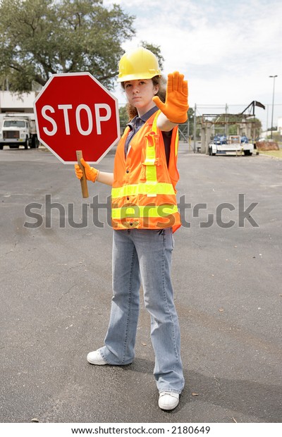A female construction worker holding a stop sign. \
Full body view.